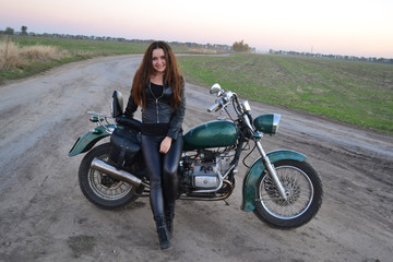 Fototapeta na wymiar Biker sexy woman sitting on vintage custom motorcycle. Outdoor lifestyle toned portrait