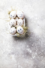 Easter holiday concept with cute handmade eggs.Funny decoration in a festive  background.Eggs with funny faces in the package.Spring mood.Copy space for Text