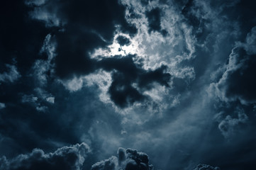 Moonlight shines behind a cloudy at night. serenity nature background.