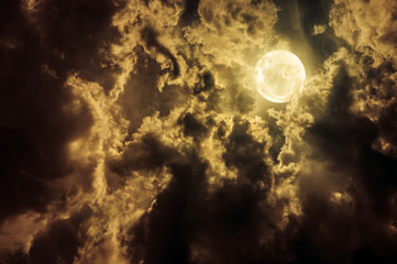 Landscape of sky with dark clouds at nighttime. Beautiful full moon behind partial cloudy with moonlight.