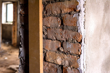 Part of brick doorway on plaster wall. 