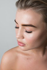 Fototapeta premium Closeup portrait of a young girl with long eyelashes and nude makeup
