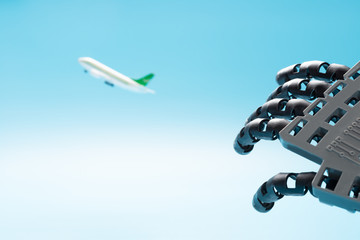 robotic hand reaching a flying aircraft concept of AI controlls the flights