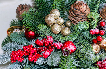 Obraz na płótnie Canvas Christmas composition of pine branches, golden Christmas decorations, red berries and artificial snow.
