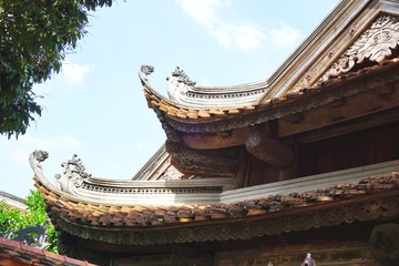 Traditional temple roof silhouette against blue sky in Southeast Asia