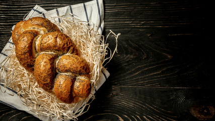 Traditional jewish bread brown challah on wooden background. Rustic concept. Close up