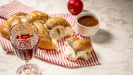 Traditional jewish bread brown challah on white wooden background with fruits and honey. Brioche bread on breakfast table