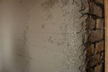 Construction worker plastering wall using pneumatic textured spray gun