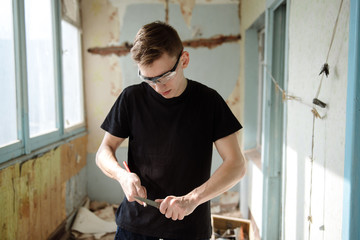 A man sharpens a pencil with a knife
