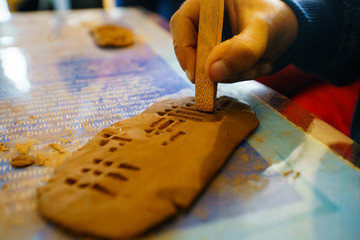 Children education sumerian clay tablet. Ancient type of Akkad empire style cuneiform writing in brown clay with tool. kids education. children education clay