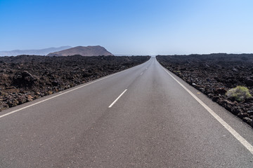 Spain, Lanzarote, Endless straight street through black lava fields