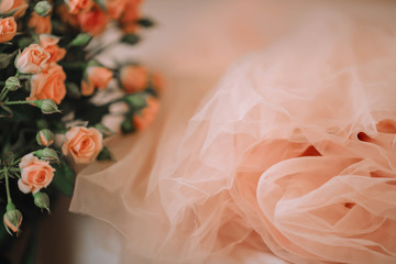 A skirt or a dress from tulle and a bouquet of roses of coral color.Trendy colors spring-summer 2019.