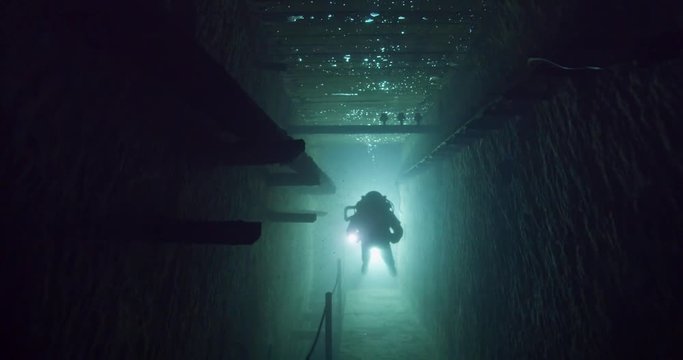 Silhouette of a diver exploring the Kobanya underwater mines, Budapest
