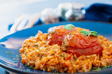 stuffed tomatoes with rice on a white plate