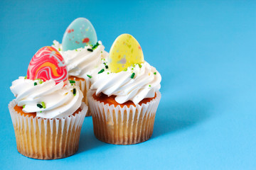 Easter vanilla cupcakes on blue background