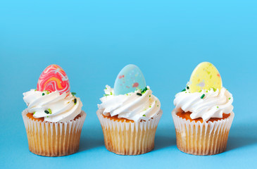 Easter vanilla cupcakes on blue background