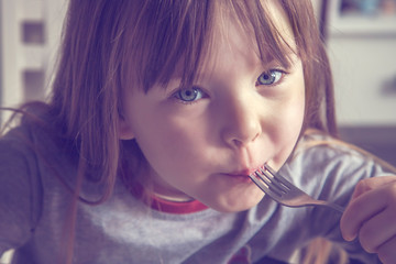 Charming little girl holding a fork Horizontal