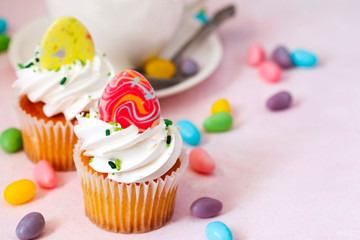 Easter vanilla cupcakes on pink background, copy space