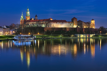 Krakow, Poland. Wawel Hill with Wawel Royal Castle and Wawel Cathedral in twilight. View from Debnicki bridge across Vistula river.