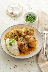 Chicken legs braised in curry and coconut sauce. With rice for garnish.