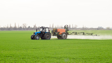 Tractor with a spray device for finely dispersed fertilizer.