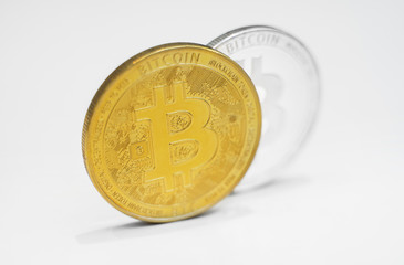 Physical version of silver and golden bitcoins on white background.