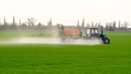 Fototapeta premium Tractor with a spray device for finely dispersed fertilizer.