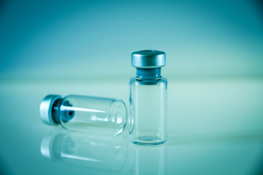 Two Vaccine Bottles On Blue Background