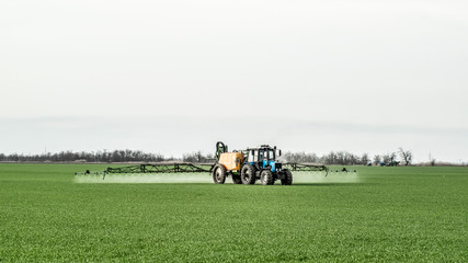 Tractor with a spray device for finely dispersed fertilizer.