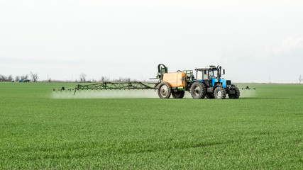 Obraz premium Tractor with a spray device for finely dispersed fertilizer.