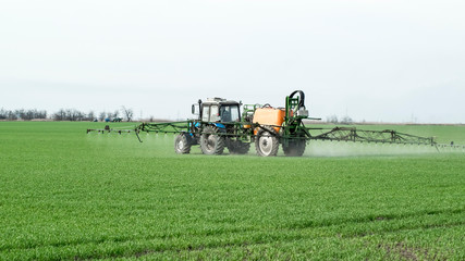 Fototapeta na wymiar Tractor with a spray device for finely dispersed fertilizer.