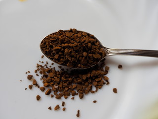 coffee beans in spoon isolated on white