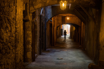Woman walking through the "Rue Obscure" (Hidden Street), Villefranche, south of France