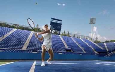 Beautiful female tennis player serving outdoor on professional tennis court.