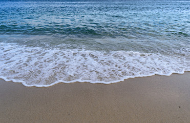 Fototapeta na wymiar Atlantic Ocean - Blue sea with wave foam spreading in the sand after busting