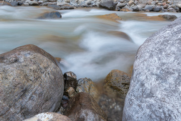 Fliessendes Wasser im Fluss zwischen Felsen