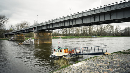Small port for one boat. Transporting people down the river. Old traffic, bridge under...
