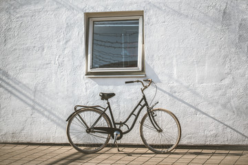 Fototapeta na wymiar Retro bicycle on roadside with vintage concrete wall background