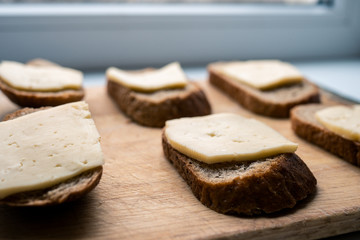 six cheese sandwiches. poor sandwich. ascetic food. healthy food. not skillful cooking. loaf of bread with a piece of cheese closeup
