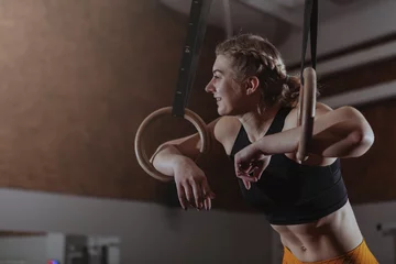 Fototapete Rund Happy healthy athletic woman laughing, looking away, resting after gymnastic rings workout. Cheerful crossfit female athlete relaxing at the gym, after exercising © mad_production