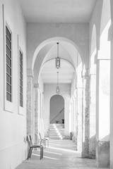 A long corridor under an arcade, with the light passing through the arches and columns. Cross vault.