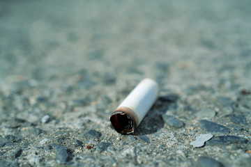 Cigarette butts in a sidewalk close-up.