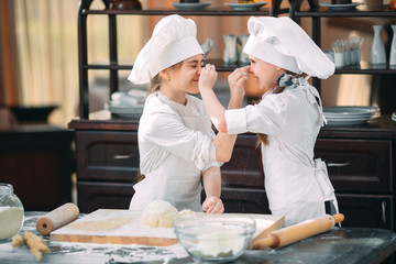 funny girls kids are preparing the dough in the kitchen.