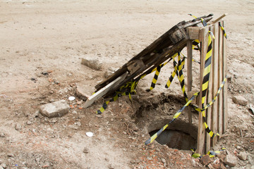 Building and construction materials for sale stored on metal shelves outdoors in a warehouse yard together with wooden pallets for loading