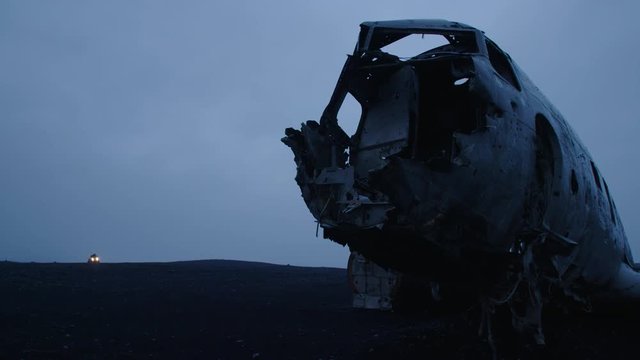 Man driving a quad to a wrecked plane on an Iceland beach