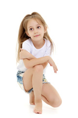 The little girl is on her knees.