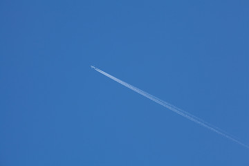  Airplane flying in the blue sky among clouds and sunlight
