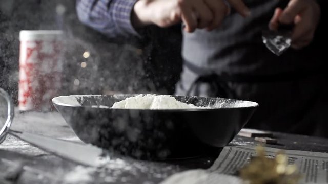 Cook throws butter into flour on a wooden table, cooking in slow motion, new year item