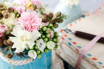 Bouquet of pink carnations and yellow Kalanchoe blossfeldiana flowers in blue ceramic vase.