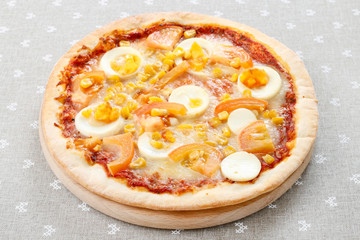 Easter pizza with eggs, cheese, corn and tomato sauce.